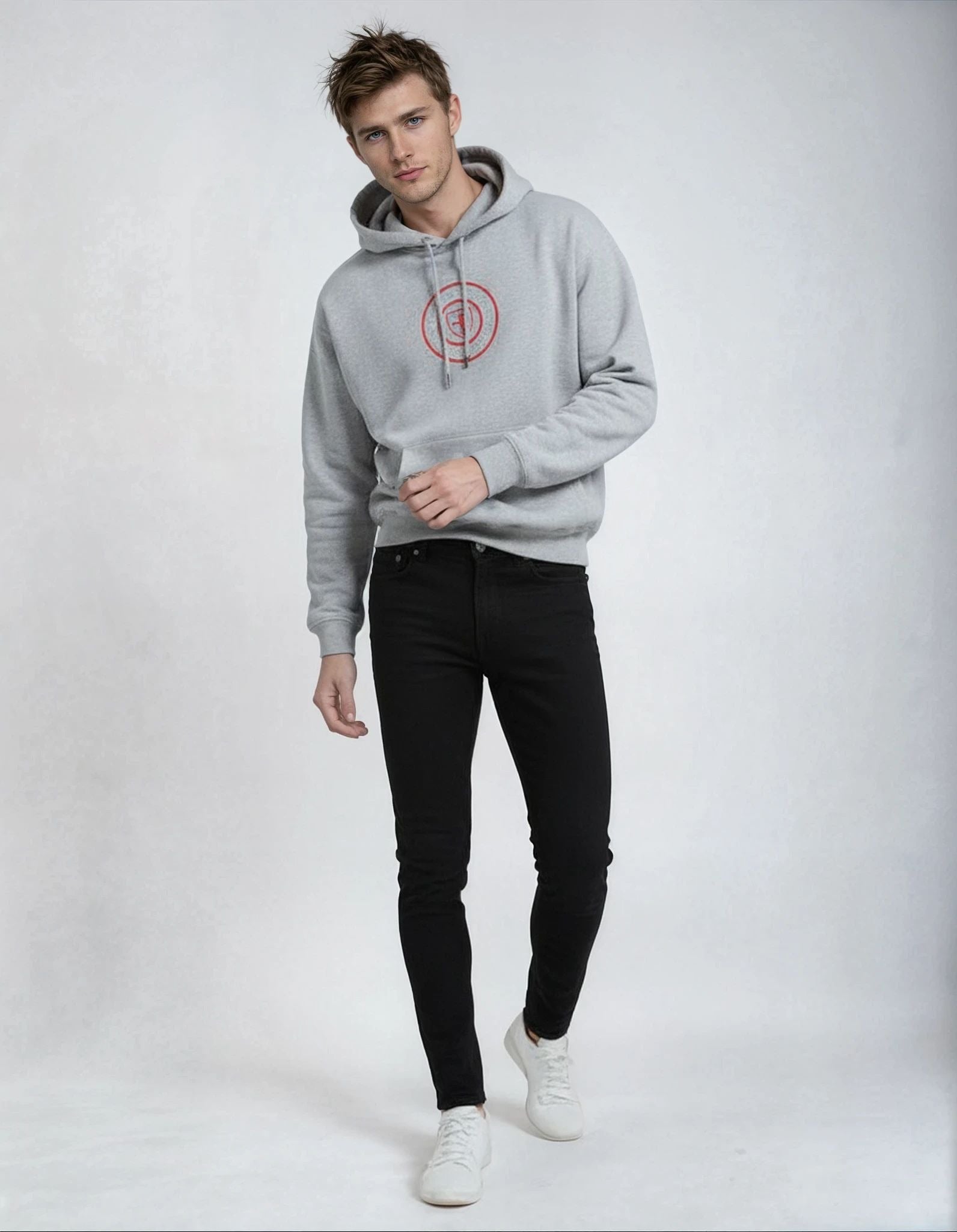 Man wearing a gray paganus hoodie with a red logo and black pants on a white background