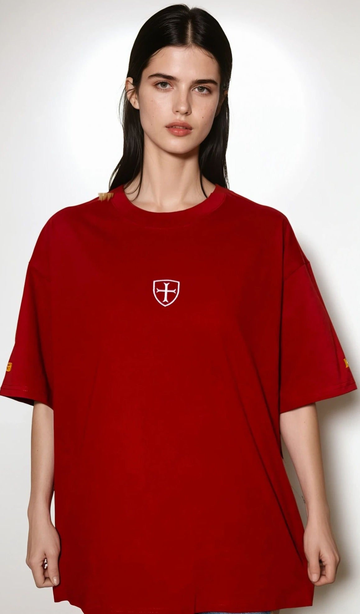 Person wearing a red t-shirt with a logo on a white background