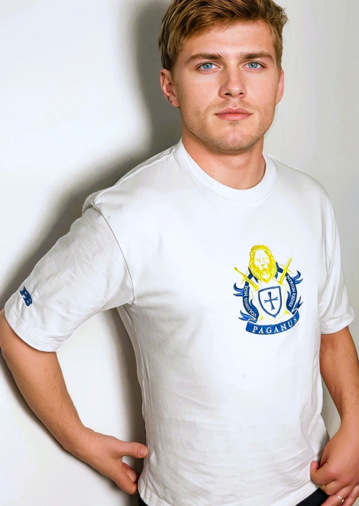 Man wearing a white t-shirt with a logo on a plain background