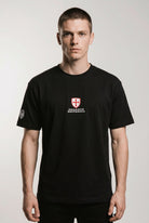 Man wearing a black t-shirt with a logo on a white background