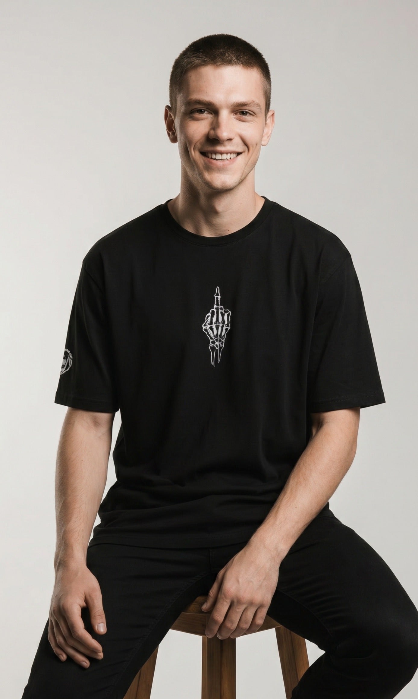 Man wearing a Paganus Britannia black t-shirt with a fuck you middle finger design in white silk  embroidery