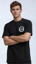 Man wearing a paganus britannia black t-shirt with a white logo