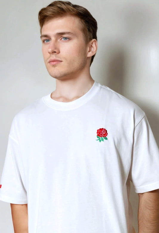 Man wearing a white t-shirt with a red rose emblem on a plain background