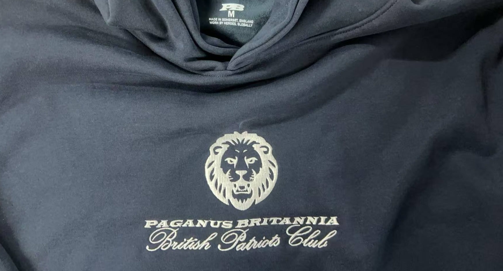 Navy blue hoodie with a white logo and text on a dark background