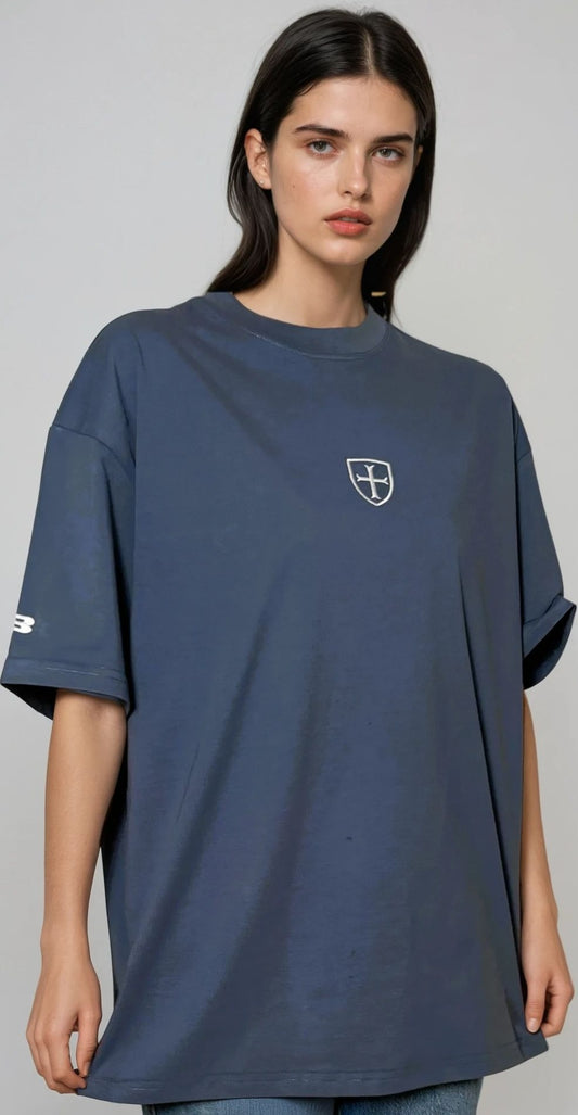 Woman wearing a navy blue t-shirt with a logo on a gray background