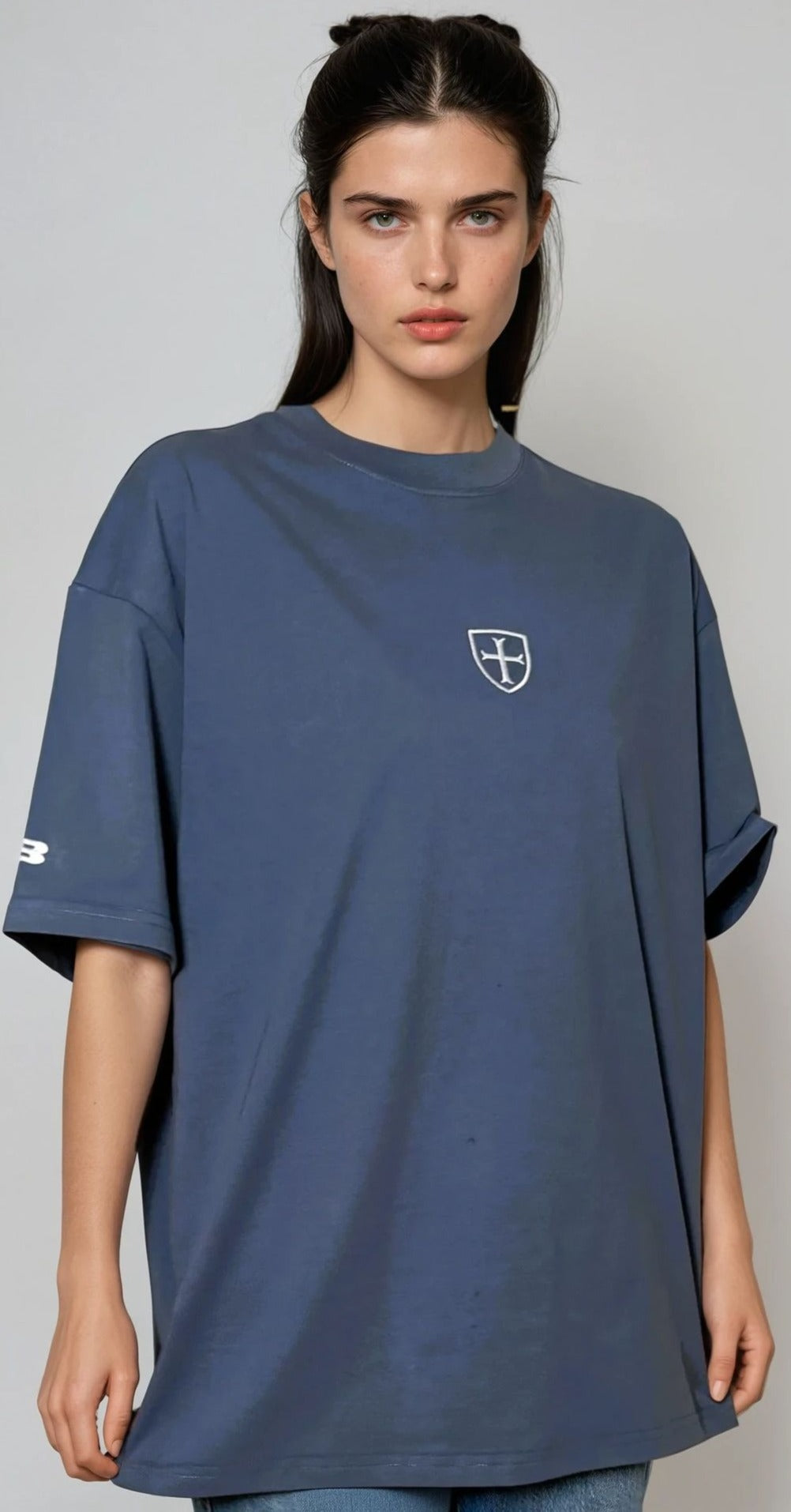 Woman wearing a blue t-shirt with a logo on a gray background
