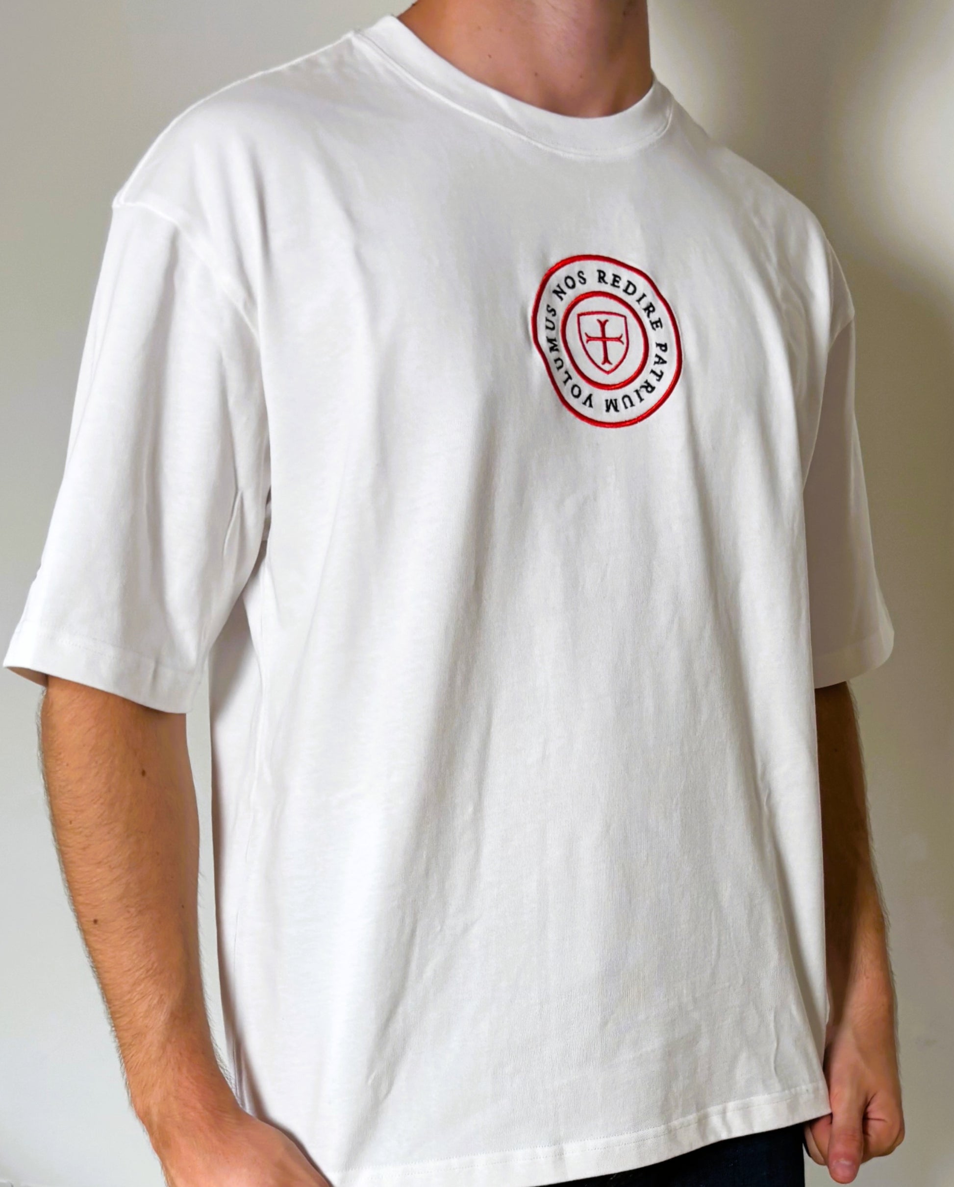 White t-shirt with a red and black logo worn by a person against a plain background
