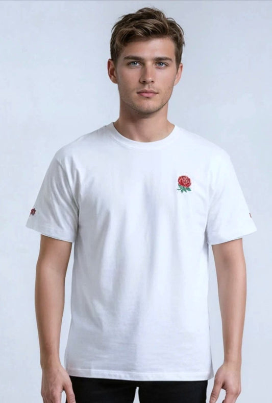Man wearing a white paganus  t-shirt with a red rose emblem on a light gray background
