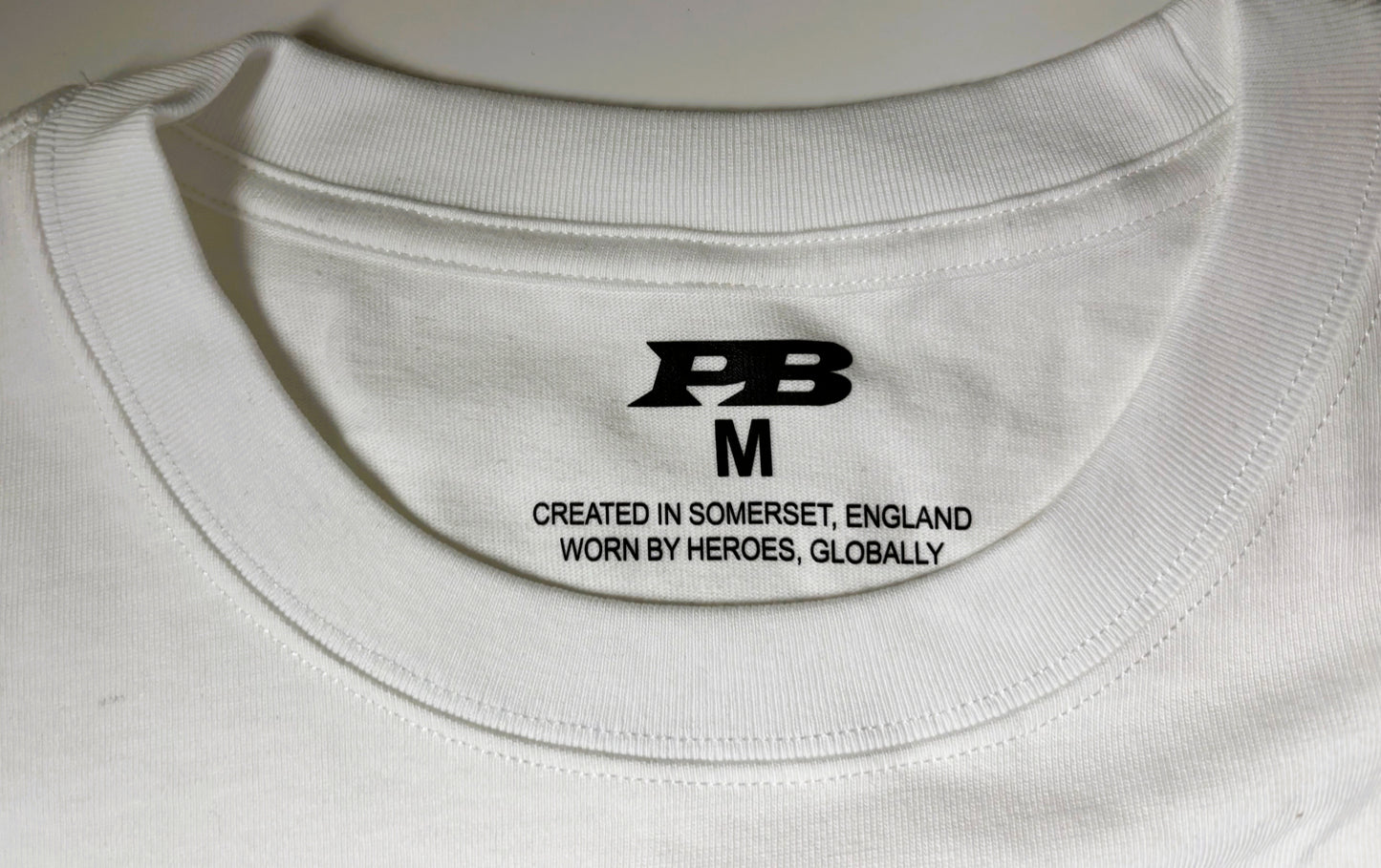 Man wearing a white 280 gsm t-shirt with a blue logo 