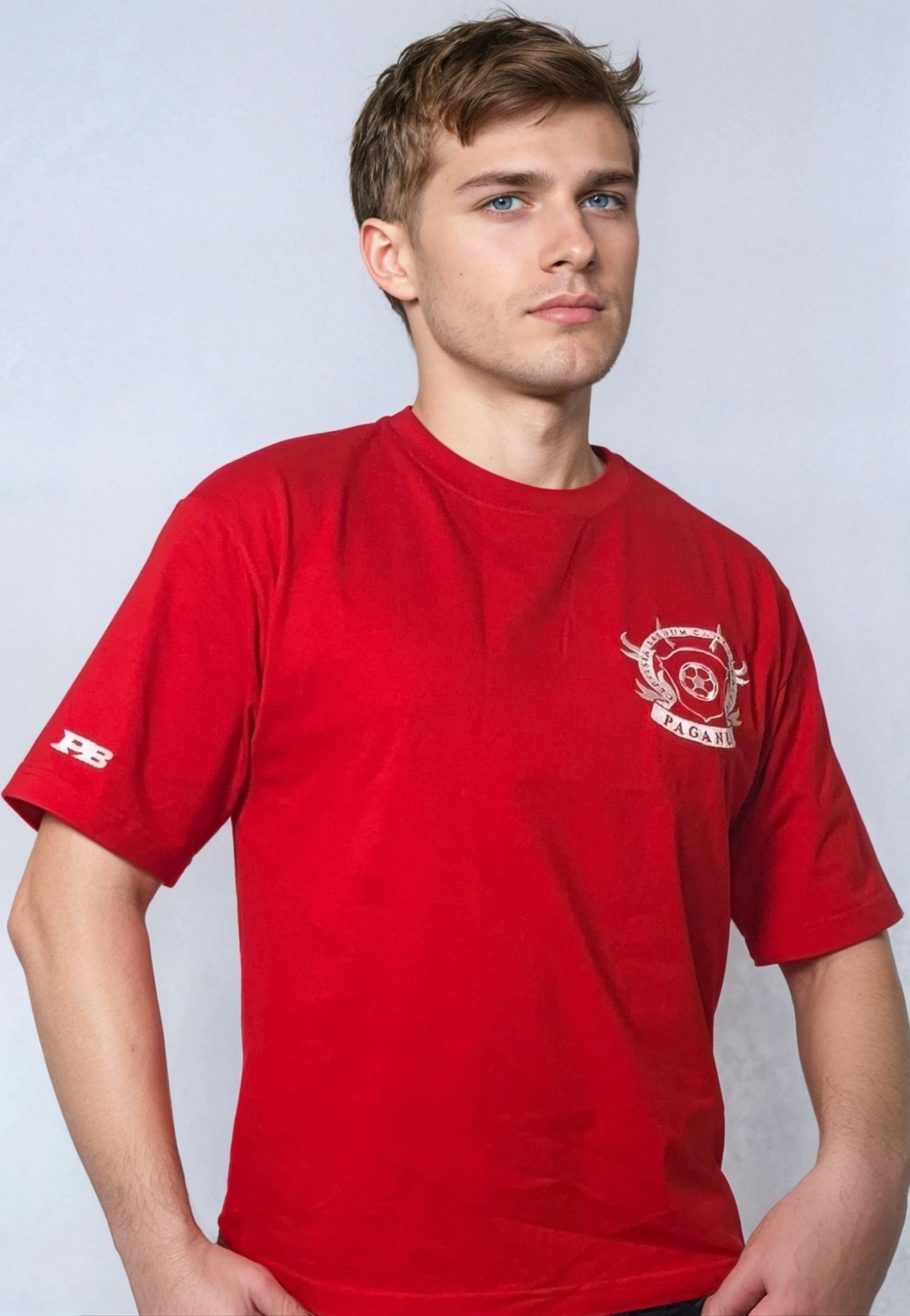 Person wearing a red t-shirt with a logo on a plain background