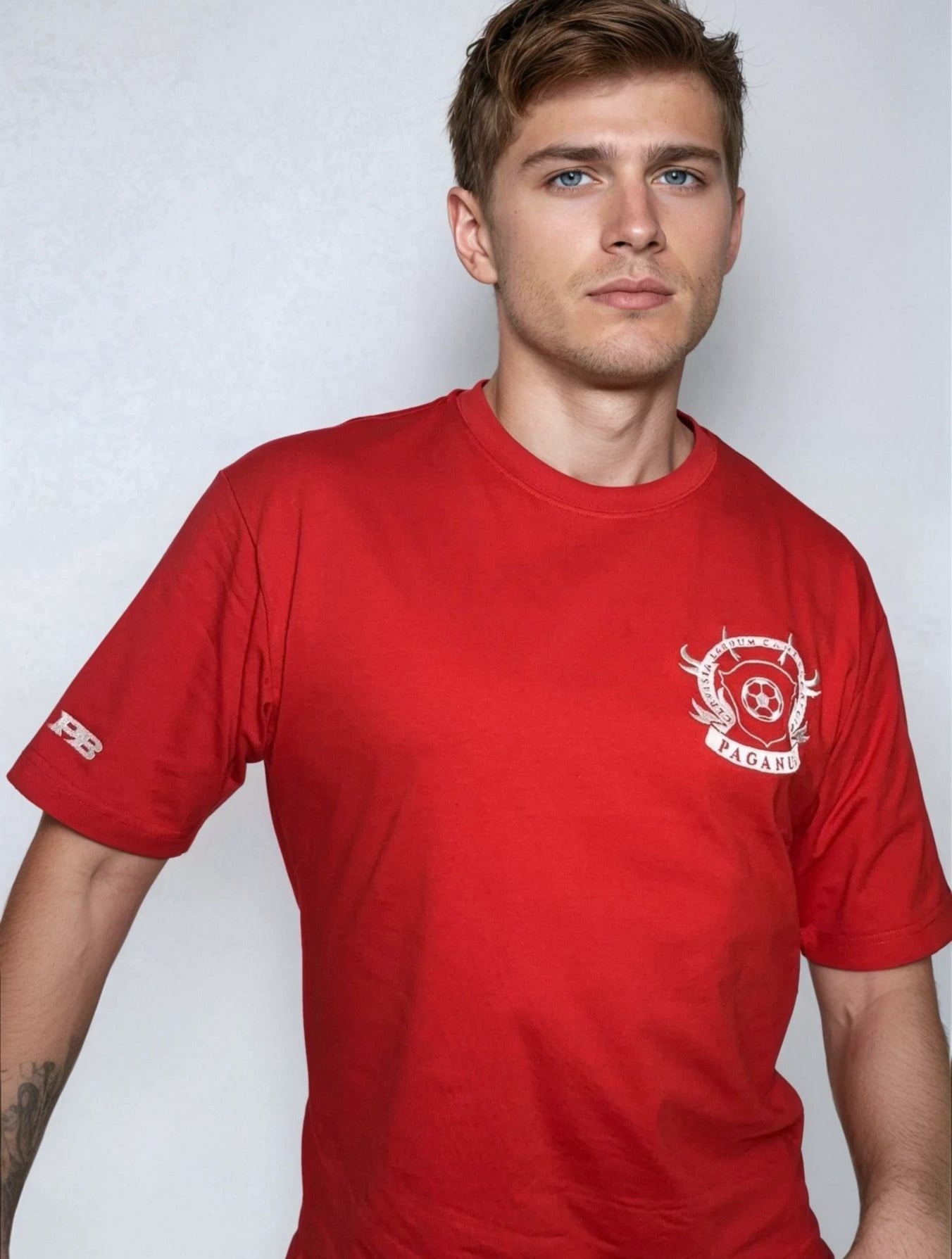 Man wearing a red t-shirt with a logo on a white background